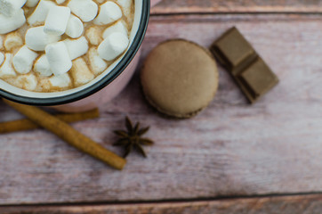 Cocoa drink with spices, zephyr on wooden background