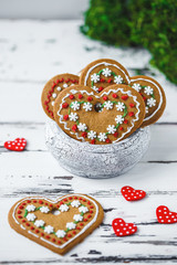 Gingerbread Cookies hearts in a cup on a white wooden background. Valentines day concept