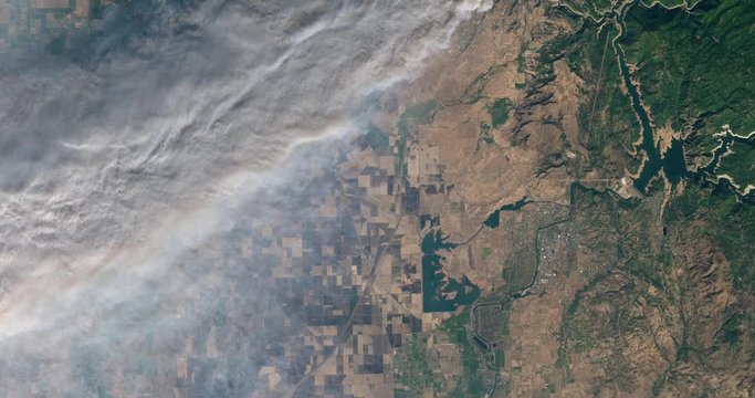 Very high-altitude overflight aerial of thick smoke from the Camp Fire, California. Clip loops and is reversible. Elements of this image furnished by USGS/NASA Landsat
