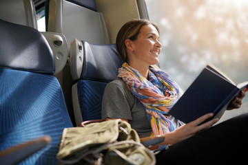 Relaxed young woman reading on the train