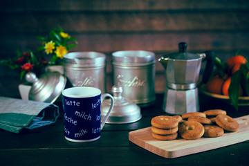 Romantic Breakfast with flowers, with a cup of milk, coffee, biscuits and fruit.