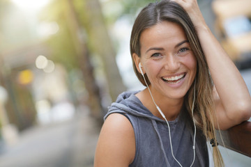 A very happy young woman laughing in a city setting