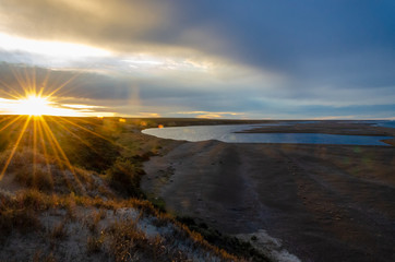 View of a shore with a lake on sunset