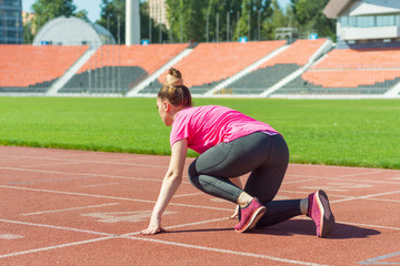 A young girl in the stadium is preparing to start.