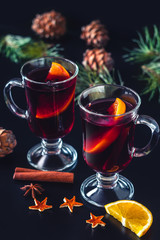 Festive mulled wine on the dark background.Holiday decorations, cones, pine twigs