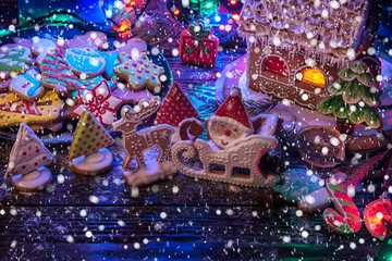 Fototapeta na wymiar Gingerbread house and figures with lights on dark background, xmas theme