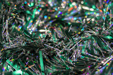 Colorful Christmas tinsel. New year's fluffy green and silver tinsel. Sparkling ornament decoration concept.holiday background