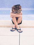 Boy in diving equipment sitting near pool