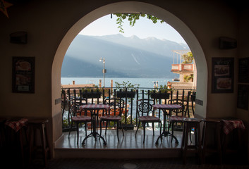 beautiful view of Lake Garda and the mountains fron the balcony of cafe in the town of Limone sul Garda in the sunny morning