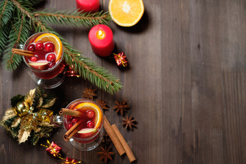 Mulled wine on a wooden background with candles, pine branches and Christmas lights. Selective focus.  Copy space