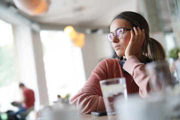  Young woman inside an urban space with headphones and devices