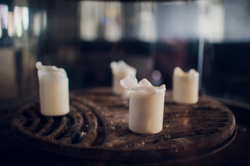 Obraz na płótnie Canvas White candles on the table on the restaurant.