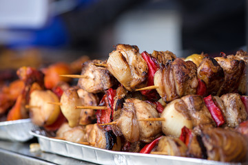 Close up of traditionally grilled pork and beef meat on a wooden stick. Eastern European traditional shish kebab with grilled vegetables.  