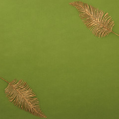 Square texture two gold leaves or feathers in the upper left and lower right corners, iridescent sequins. Christmas background.