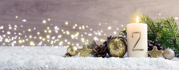 Second Advent. Christmas background with Advent candle and golden decoration.