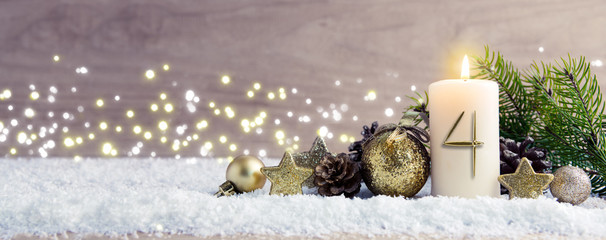 Fourth Advent.Christmas background with Advent candle and golden decoration.