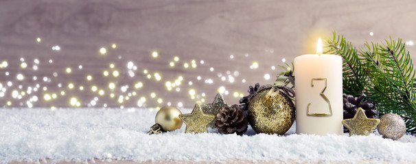 Third Advent.Christmas background with Advent candle and golden decoration.