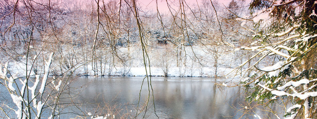 Winter landscape with snow covered trees and forest lake.