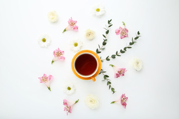 Obraz na płótnie Canvas Flowers with cup of tea on white background