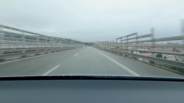 Approaching and driving into tunnel on the E90 with town of Campofelice di Roccella visible below in Sicily, Italy.