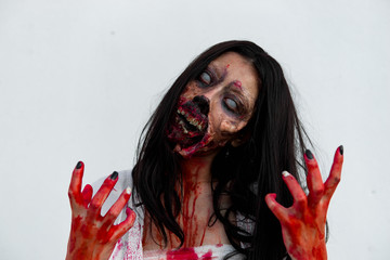 Portrait of asian woman make up ghost face with blood on white background,Horror scene,Scary...