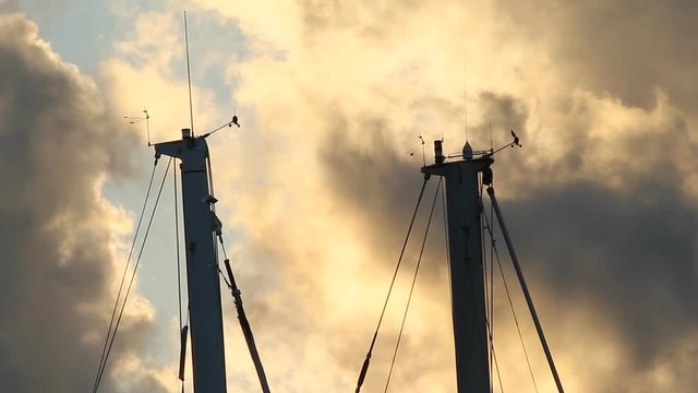 Boat masts with Weathervanes, Anemometers and clouds. Palermo, Sicily, Italy.