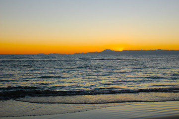 Sea surf on a sandy beach in the evening.