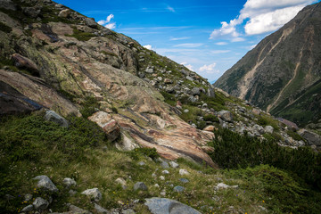 Fototapeta premium Valley in the Alps (Austria, Europe). Beautiful nature, high mountains, summer day, snowy peaks. Hike in the rocks, traveling with a backpack.