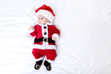 Little boy in christmas costume lying on bed