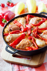 Chicken thighs and legs baked over a bed of rice and red bell pepper