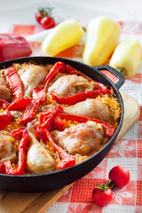 Chicken thighs and legs baked over a bed of rice and red bell pepper