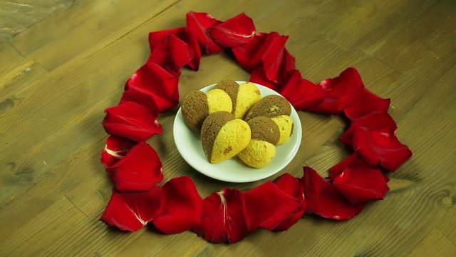 The girl puts a plate of cookies in the middle of the heart.