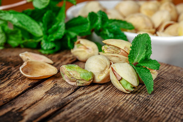 Bowl with pistachios on a wooden table.