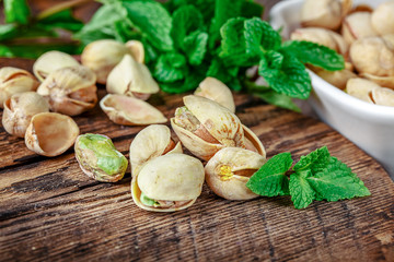 Bowl with pistachios on a wooden table.
