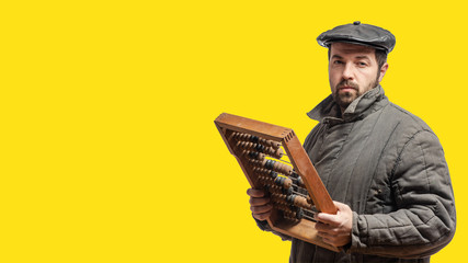 Concept: old-fashioned financial auditor with retro wooden abacus, studio shot, yellow background. Isolated, clipping path