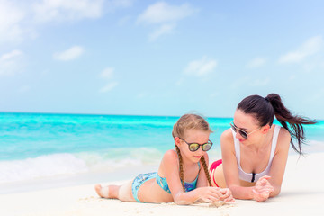 Little cute girl and young mother at tropical beach