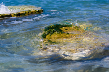 rocky sea shore with pebble beach, waves with foam