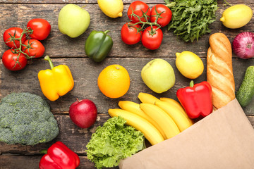 Grocery shopping bag with food on grey wooden table