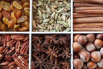 Close up photo of cinnamon barks, hazelnuts, anise,  pecan nuts, raisins and cardamom. Top view, macro