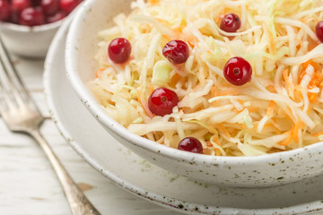 Cabbage salad. Traditional russian appetizer sauerkraut with cranberry and carrot close-up