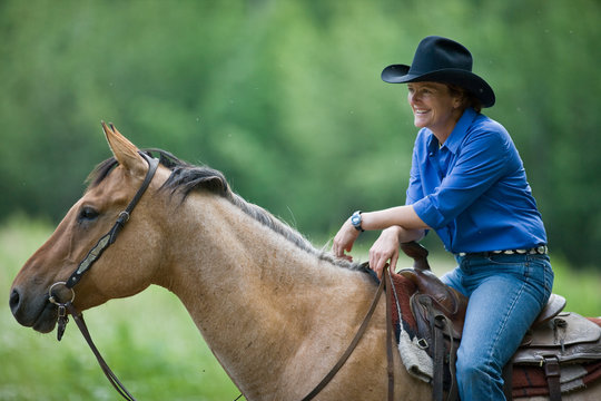 Mature woman on horseback smiling