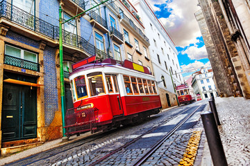 Tranvía en la calle tradicional escénica al atardecer con sol y nubes. Lisboa, Portugal. Colorida...