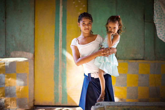 View of a teenage girl carrying her sister.