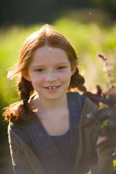 Portrait of a young girl smiling in a field.