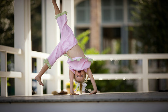 Portrait of a young girl doing a cartwheel.