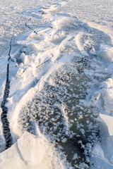 Obraz premium View from above on frozen lake texture. Frost created a beautiful decoration from crushed ice pieces and snow. Winter vertical background.