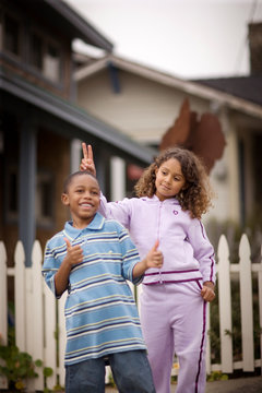 Young boy and his young sister playing on a suburban street.