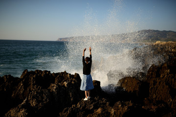 girl on the background of waves and rocks, portugal