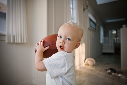 Young male toddler holding a rugby ball