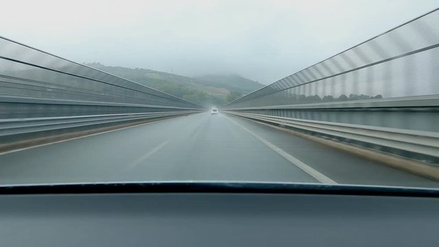 Crossing long bridge in the rain. Time lapse. Driving from Messina to Palermo on Autostrada E90, Sicily, Italy.